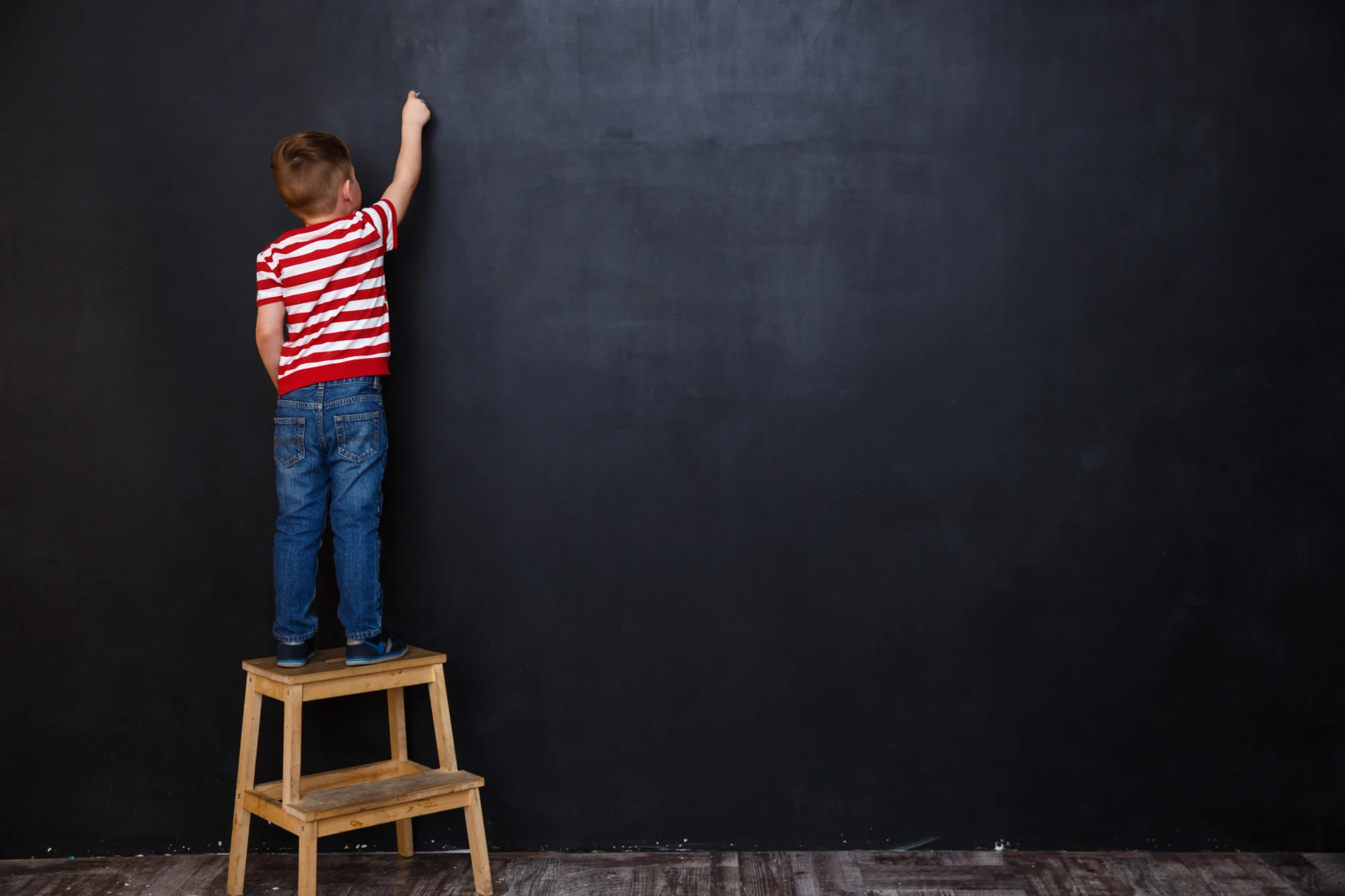 back-view-cute-little-kid-boy-writing-with-chalk